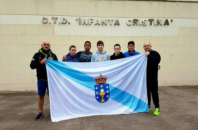 Antonio Rebouras y Oscar Eiroa, enharbolan la bandera de Galicia que rodea a los jóvenes gérmenes del boxeo galaico que, a buen seguro, han cosechado grandes conocimientos para un fructífero futuro en su carreras deportivas. Ellos son los becados en el último Plan Nacional de Tecnificación Talía Muiños y Yoelbis Medina del Club de Lucha Noia. Rubén Pérez y Angel López de la Esuela de Boxeo el Canario y Amancio Martinez del Thunder Team.