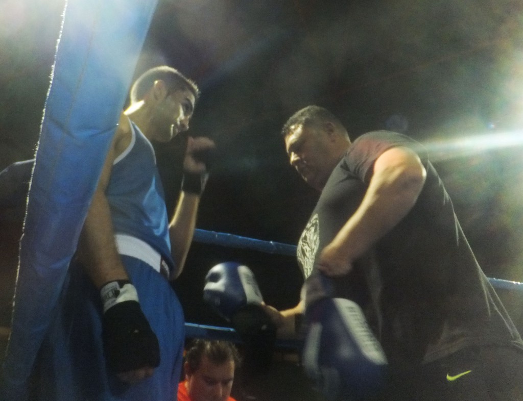 El ritual de competición se inicia con el maestro Luis Torrado enguantando y aleccionando al joven alumno Neo. boxeodemedianoche Blanco